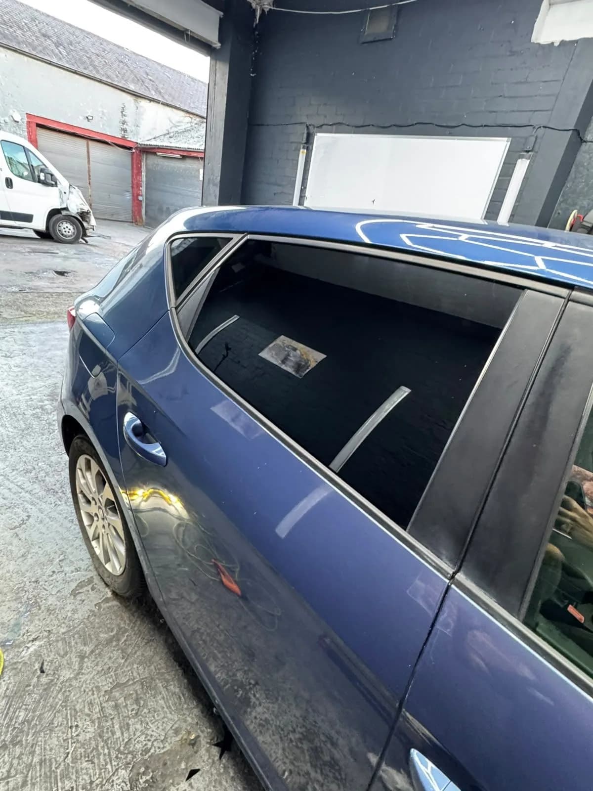 Blue hatchback with dark rear quarter glass