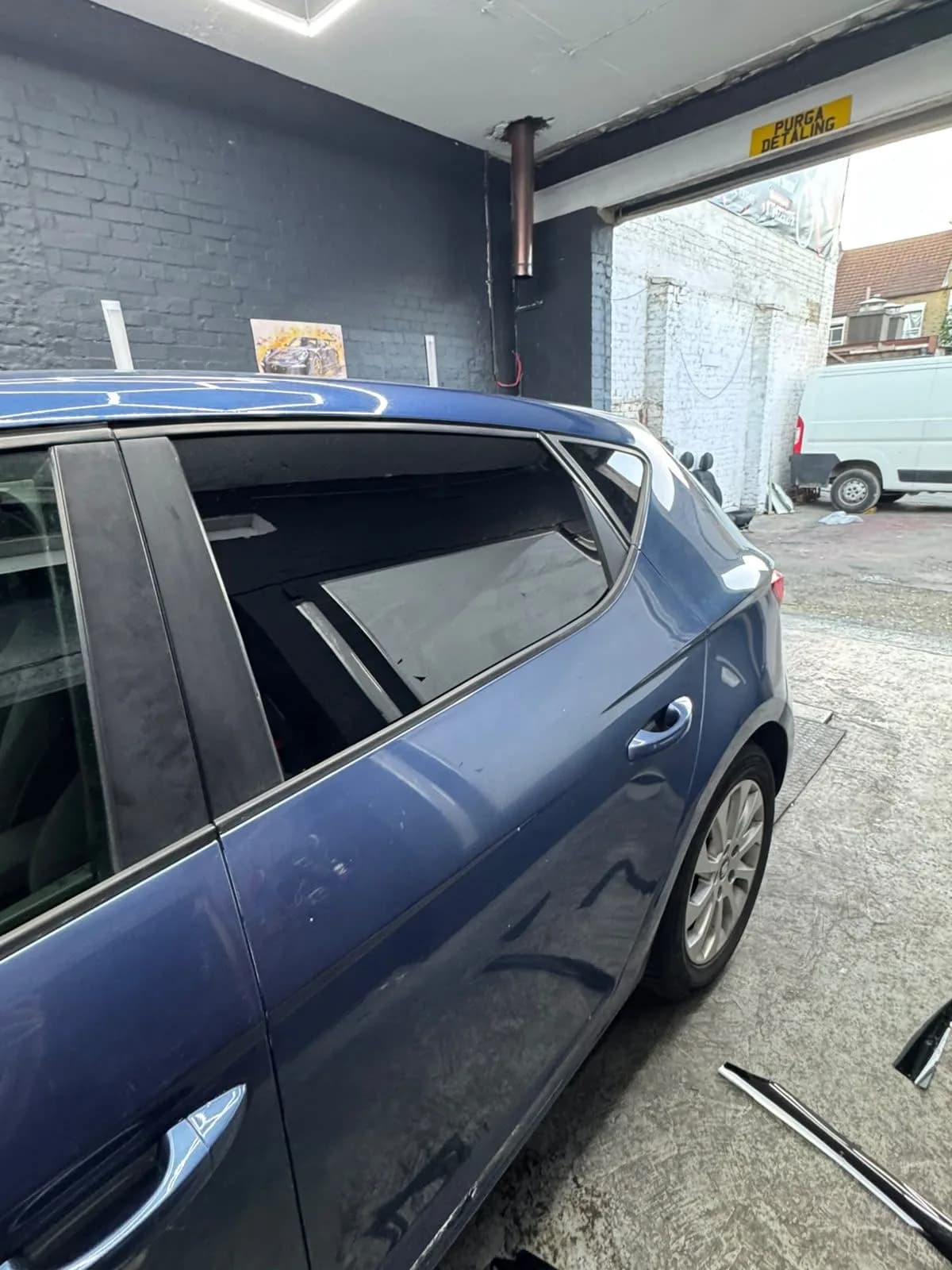 Window tint fitted by AM TINTS on a blue hatchback