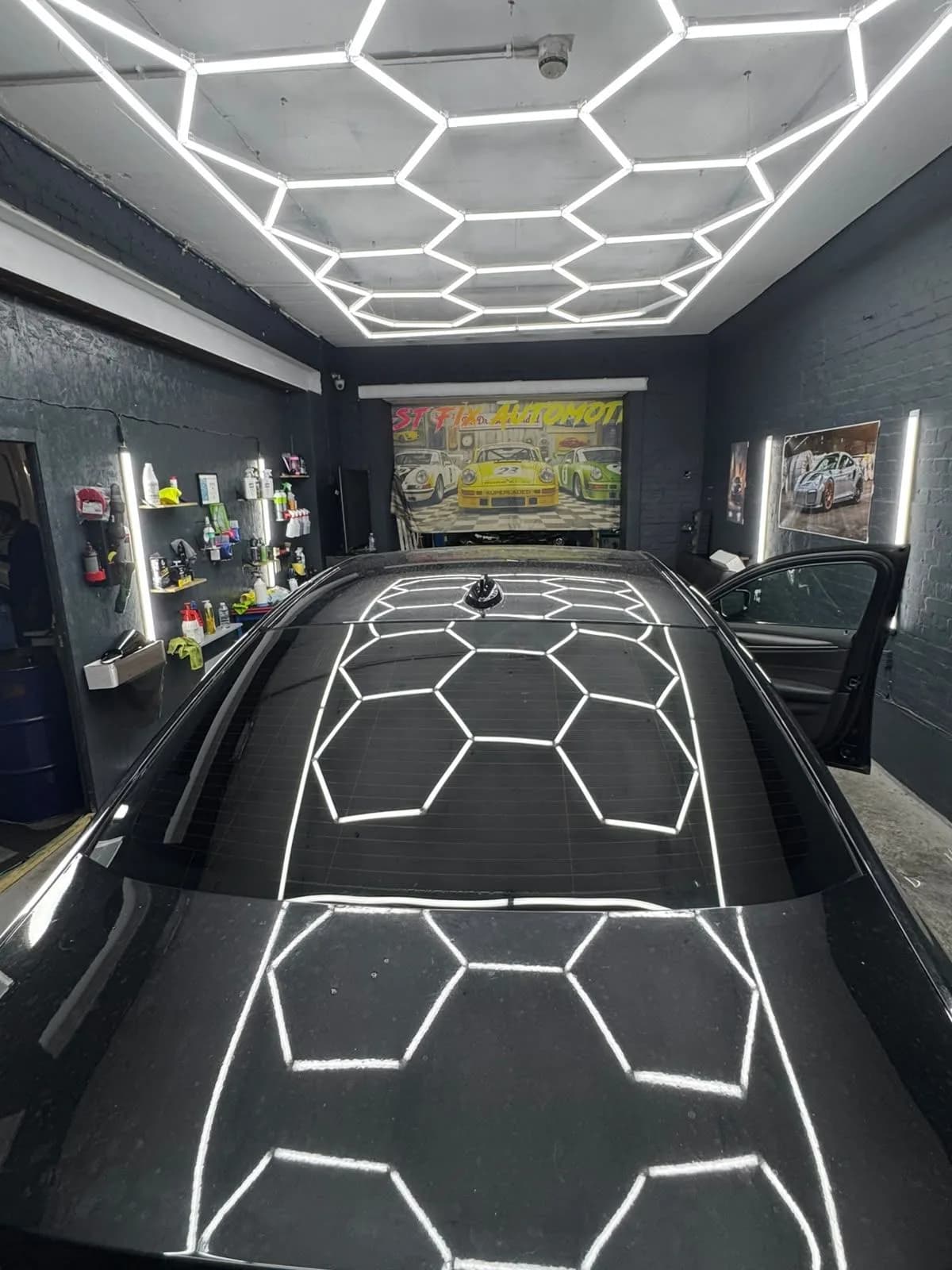 Car roof glass reflecting the workshop lighting